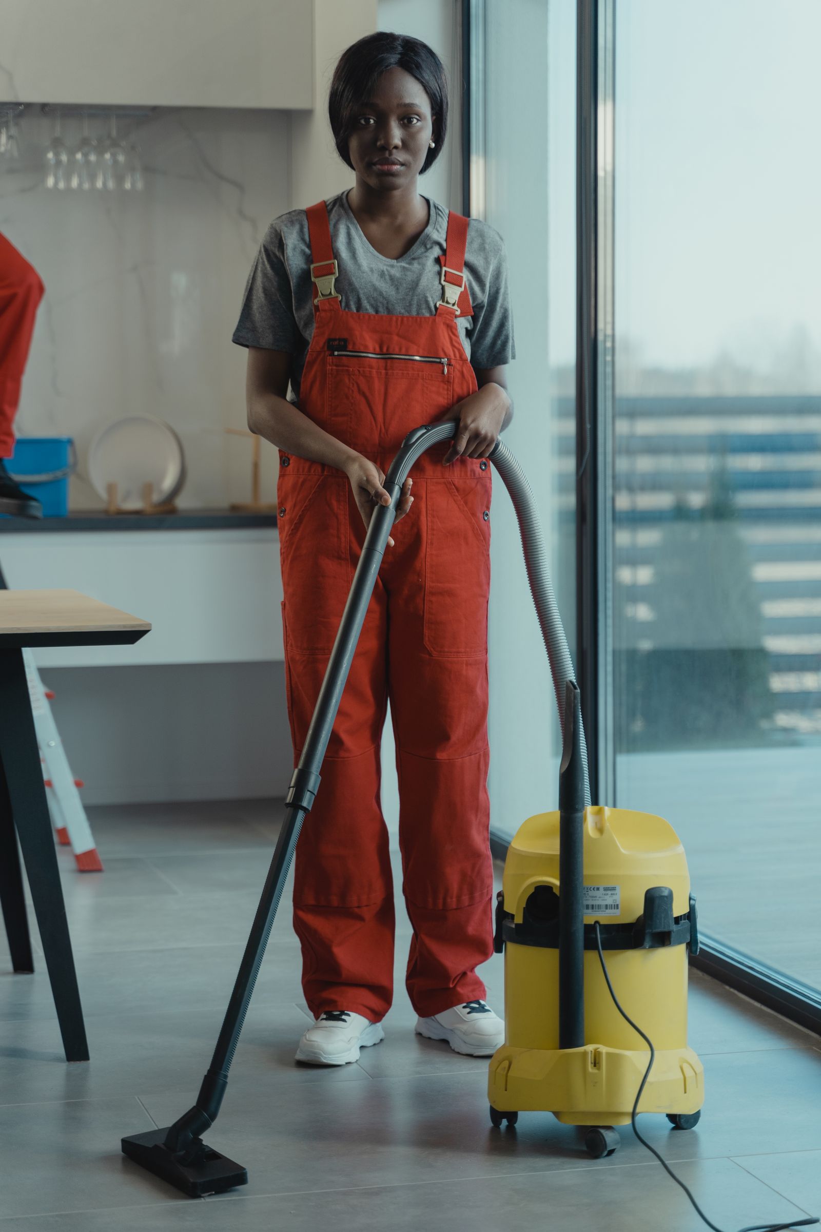 Profesional de limpieza aspirando un espacio moderno